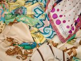 une pile d'écharpes et de bonnets posée sur un lit