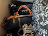 a box full of purses and handbags sitting on a bed