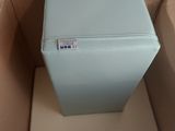 a blue refrigerator in a cardboard box on the floor