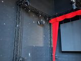 a stage with a red curtain and a projector screen