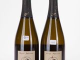 deux bouteilles de vin posées l'une à côté de l'autre sur une surface blanche