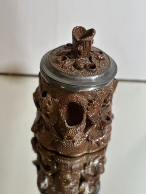 un vase marron orné d'un ours, posé sur une table