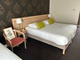 two beds in a hotel room with a chair in front of them