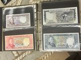 four different types of paper money in a binder on top of a table