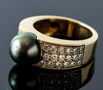 an image of a black pearl and diamond ring on a black surface