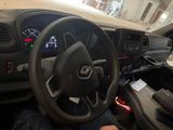 dashboard of a car with a person sitting in the driver ' s seat holding a steering wheel