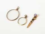 three different types of jewelry including a magnifying glass, a ring, and a pen