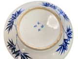 blue and white plate with bamboo leaves on it on a white background