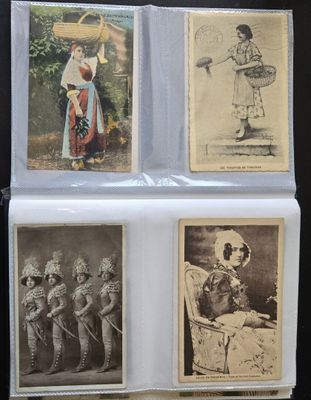 Plusieurs vieilles photos de personnes en costume sont exposées sur une table