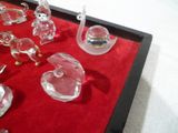 de nombreuses figurines en verre disposées sur un plateau rouge