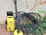 a yellow pressurer sitting on the ground next to a green plant