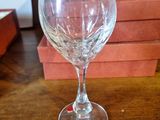 a wine glass sitting on a table next to a stack of books