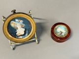 a miniature picture of a woman in a hat next to a small wooden box