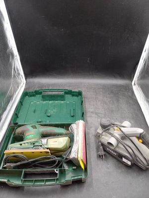 une boîte verte posée par terre, contenant des outils