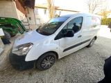 La camionnette blanche est garée sur le gravier de l'allée.