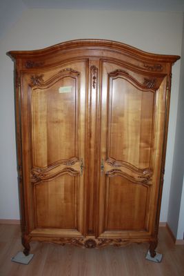 a large wooden armoire in the corner of a room