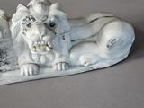 a statue of a lion laying down on the ground