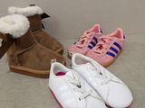 trois paires de chaussures blanches et roses posées sur un lit
