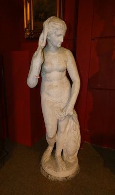 une statue représentant une femme tenant un sac dans une pièce