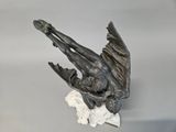 statue of an angel on a rock on a white surface
