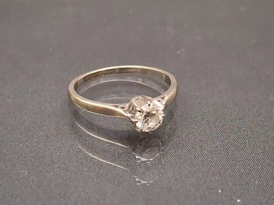 une bague sertie d'un diamant, posée sur une table