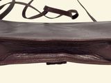 a brown leather bag with a strap on it