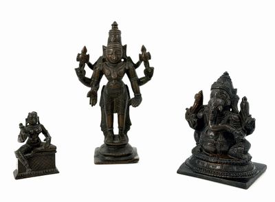 three bronze figurines of hindu deities on a white background
