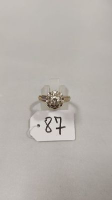 gros plan d'une bague sur une surface blanche avec une étiquette de prix