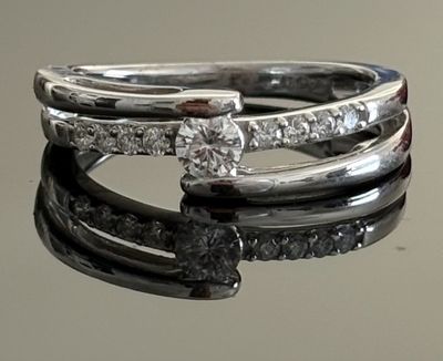 a close up of a diamond ring on a reflective surface