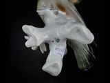 a bird that is sitting on top of a figurine