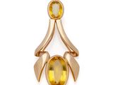 un gros plan d'une bague en or sertie d'une pierre jaune