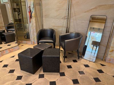 une chaise noire et deux tabourets noirs dans une pièce