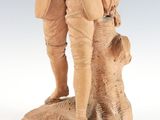 figurine of a man standing on a tree stump with a dog
