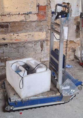 a machine that is sitting on the ground next to a wall