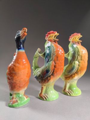 trois figurines en céramique représentant des oiseaux colorés sur un fond gris