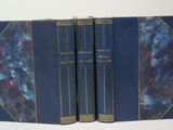 three blue books sitting on top of each other on a white surface