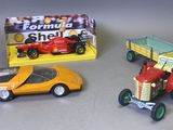 trois petites voitures et un petit tracteur posés sur une table