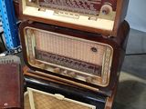 several old radio ' s stacked on top of each other in a room