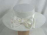 un chapeau blanc orné d'un nœud sur le dessus