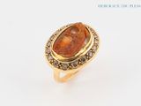 an image of a gold ring with a red stone in it