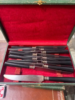 five knives in a case with a red cloth
