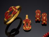 an image of a red and gold jewelry set on a black surface