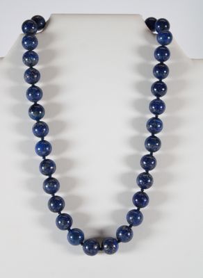 un gros plan d'un collier orné de perles bleues sur un mannequin
