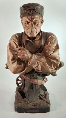 statue of an old man with a hat on his head and arms crossed