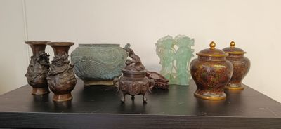 many different vases on a table with one of them sitting on top of the other