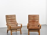 deux fauteuils en cuir marron dans une pièce aux murs blancs