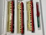 four train cars in a white box on a table