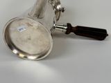 a silver coffee pot with a wooden handle on a white table