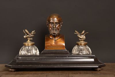 une photo représentant la statue d'un homme assis sur une table en bois