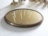 un miroir posé sur une table, dans lequel se reflètent des bougies